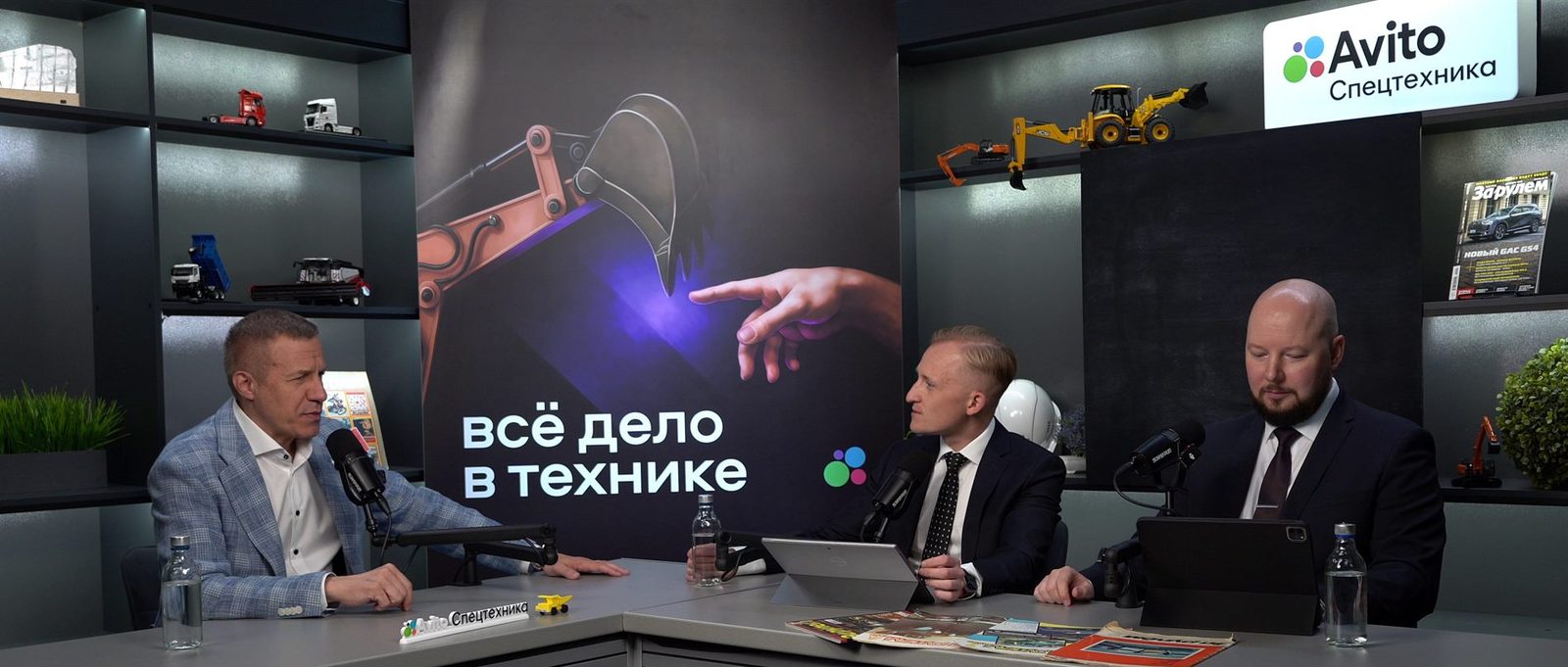 The OKVideo.Pro sports set dressed for the Avito Spetstekhnika business show: three people at the desk